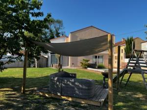 een hangmat op een houten terras in een tuin bij Maison familiale 4 chambres avec jardin et piscine in Saint-Aignan-Grand-Lieu