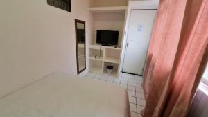 um pequeno quarto com uma cama e uma televisão em São Luís Hostel em São Luís