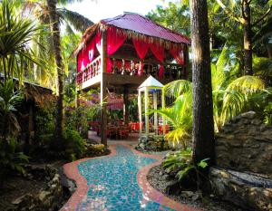 un complejo con un restaurante en medio de un jardín en ABEZZA Resort And Spa - formerly Belize Boutique Resort & Adventure Spa, en Maskall