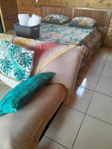 um sofá com almofadas ao lado de uma cama em LES HAUTS DE L'ANSE em Bouillante