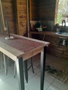 uma mesa de madeira numa cozinha com bancada em LES HAUTS DE L'ANSE em Bouillante