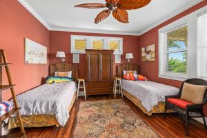 two beds in a room with red walls at 1730 Kaleka 4 Bed Poipu House, Guest House walk to Beach in Koloa