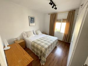 a bedroom with a bed and a table and a window at Apartamento con Licencia en Sitges in Sitges