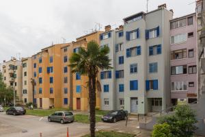 una fila di edifici in un parcheggio con una palma di Saint Vitus Apartment a Rovigno (Rovinj)
