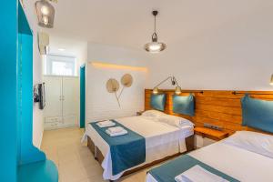 Avlu Boutique Hotel في داتشا: غرفة نوم بسريرين باللونين الأزرق والأبيض