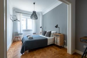 ein Schlafzimmer mit einem Bett und einer Hängeleuchte in der Unterkunft DuMont Lisbon Guesthouse in Lissabon