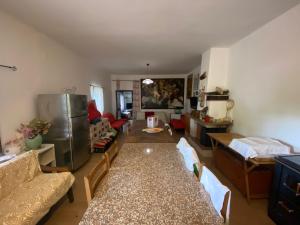 uma sala de estar com uma mesa e um frigorífico em House Edda Serena - Casa Vacanze Salerno em Pontecagnano Faiano