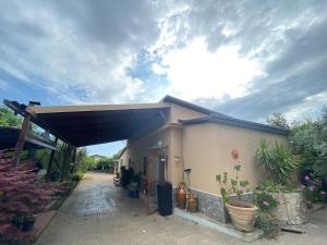 a small house with awning and potted plants at House Edda Serena - Casa Vacanze Salerno in Pontecagnano