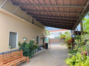a patio with a wooden bench under a wooden pergola at House Edda Serena - Casa Vacanze Salerno in Pontecagnano