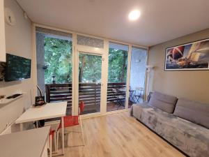 a living room with a couch and a table at Rise and Shine apartment in Juodkrantė