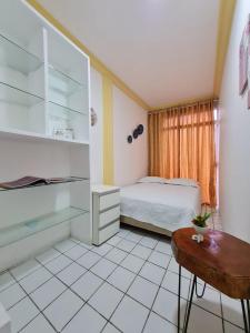um pequeno quarto com uma cama e uma mesa em São Luís Hostel em São Luís
