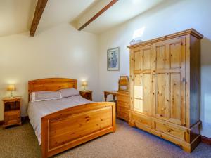 a bedroom with a wooden bed and a wooden cabinet at The Shippon in Poulton le Fylde