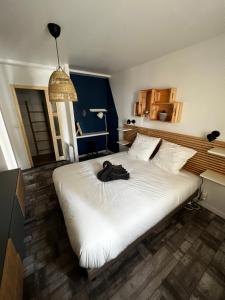 Una gran cama blanca con un par de zapatos. en Maison familiale 4 chambres avec jardin et piscine en Saint-Aignan-Grand-Lieu