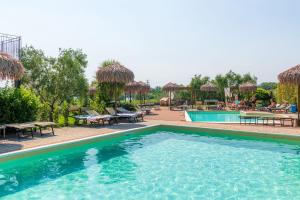 a pool at a resort with tables and chairs at Bertoletta Village Apartments in Peschiera del Garda