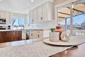 a kitchen with white cabinets and a table at The White Custom Farmhouse 5 bedroom Home in Meridian