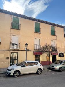 dwa samochody zaparkowane przed budynkiem w obiekcie CÉNTRICO APARTAMENTO REFORMADO EN ARANJUEZ w mieście Aranjuez
