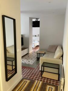 ein Wohnzimmer mit einem Sofa und einem Spiegel in der Unterkunft CÉNTRICO APARTAMENTO REFORMADO EN ARANJUEZ in Aranjuez