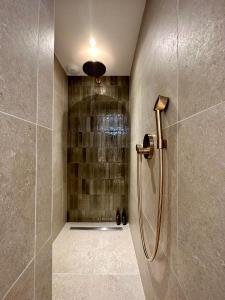 a shower stall in a bathroom with a shower at La Ferme D'Augustin in Saint-Tropez