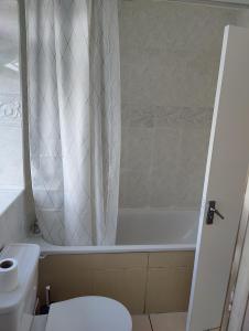 a bathroom with a toilet and a tub and a sink at Beautiful and homely accommodation, Archway in Islington near Camden town in London