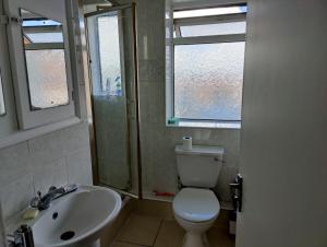 a bathroom with a toilet and a sink and a window at Beautiful and homely accommodation, Archway in Islington near Camden town in London