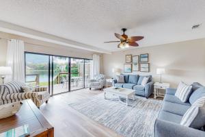 Una sala de estar con un sofá y un ventilador de techo. en Beachwalk Villa 5194, en Destin