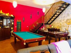 ein Wohnzimmer mit einem Billardtisch und einer Treppe in der Unterkunft Villa Safari Charm in Ribeira Brava