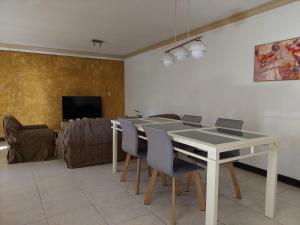 a dining room with a white table and chairs at Habitación con baño privado y estacionamiento in San Martín
