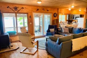 uma sala de estar com sofás azuis e uma cozinha em Leavitt Bay Shores em Ossipee
