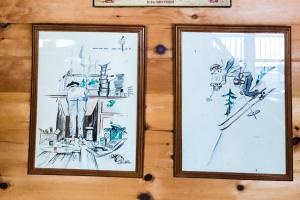 deux dessins encadrés de skiiers sur une paroi dans l'établissement Leavitt Bay Shores, à Ossipee
