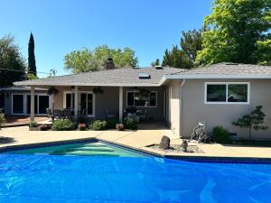 a house with a swimming pool in front of a house at Secluded Home w/pool 5 minutes from American River in Carmichael