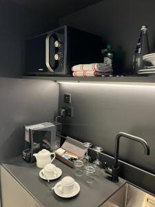 a kitchen counter with plates and glasses on a sink at Eleven by Warren Collection in Sliema