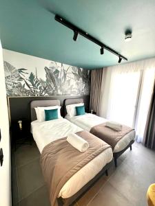 a bedroom with two beds and a painting on the wall at Eleven by Warren Collection in Sliema