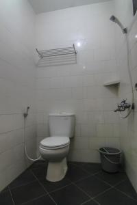a bathroom with a toilet and a shower at Hotel Cemerlang in Baturaden