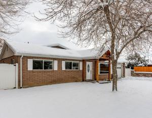 a brick house with a snow covered roof at Modern home near UVU and BYU with hot tub and mountain views in Orem