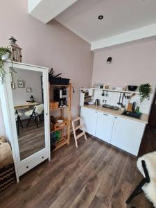 a room with a mirror and a kitchen with a table at Rabarbar in Ustroń