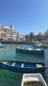 three boats in a body of water with buildings at Eleven by Warren Collection in Sliema