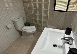 La salle de bains est pourvue de toilettes blanches et d'un lavabo. dans l'établissement Atico Alma, à Jalance