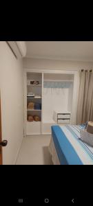 um quarto branco com uma cama e uma janela em Excelente apartamento na praia de ponta verde em Maceió