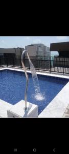 uma fonte de água em frente a uma piscina em Excelente apartamento na praia de ponta verde em Maceió