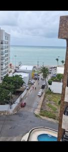 Blick auf eine Straße mit einem Parkplatz und das Meer in der Unterkunft Excelente apartamento na praia de ponta verde in Maceió