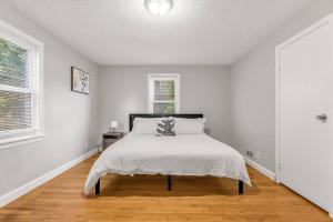a white bedroom with a bed and a window at North Haven Charm, 3BD Yale Retreat in North Haven