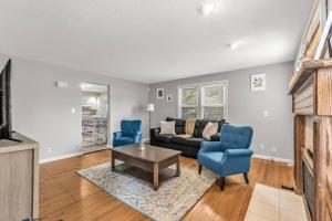 een woonkamer met een bank en 2 blauwe stoelen bij Comfy home with newly renovated interior in North Haven