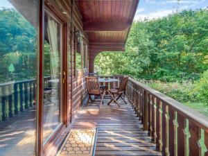 un porche de una casa con mesa y sillas en Scandinavian Lodge - Uk37188 en Legbourne