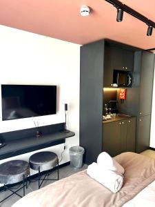 a bedroom with two stools and a tv on the wall at Eleven by Warren Collection in Sliema