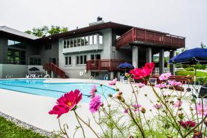 une maison avec une piscine et des fleurs roses dans l'établissement Skihaven East Glade A1, à Killington