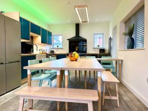a kitchen with a table with fruit on it at Large New 4 bedroom House Sleeps up to 12 - Accepts Groups - Great Location - FREE Parking - Fast WiFi - Smart TVs - sleeps up to 12 people - Close to Bournemouth & Poole Town Centre & Sandbanks in Bournemouth