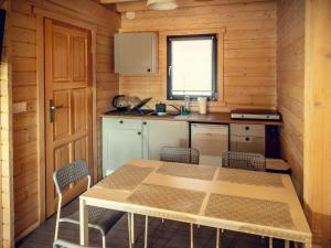 a kitchen with a table and chairs in a cabin at Cozy family cottages, not far from the sandy beach, in a quiet location, Gaski in Gąski