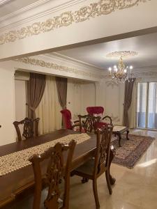 a dining room with a table and chairs and a chandelier at Luxurious, fully furnished and well-equipped apartment with modern amenities, stunning views, and convenient location for remote work or studying from home in Cairo