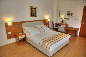 1 dormitorio con 1 cama grande y escritorio en Hotel Leonardo, en Međugorje