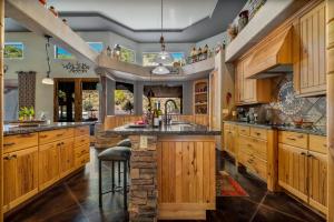 a kitchen with wooden cabinets and a stone island at Quail Mountain Desert Resort: Heated Pool, Mt Vews, all BR's King & TV's, Hiking in Mesa